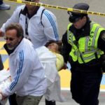 Dr. Martin Levine (bottom center in white) helps aid injured people at the finish line of the 2013 Boston Marathon following an explosion in Boston, Monday, April 15, 2013. (AP Photo/The Boston Globe, David L Ryan)